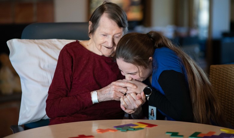 Caregiver kissing hand of dementia patient